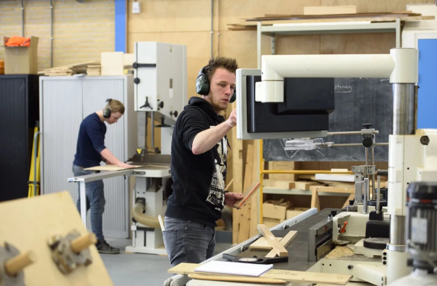 Student Allround Machinaal Houtbewerker zit aan de knoppen van de machine 