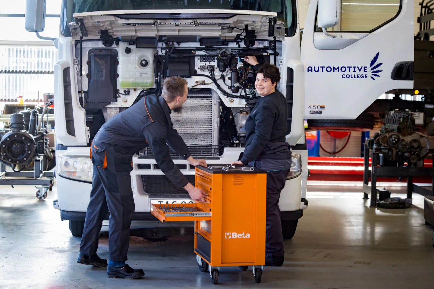 Studenten werken samen in de werkplaats aan een bedrijfsauto