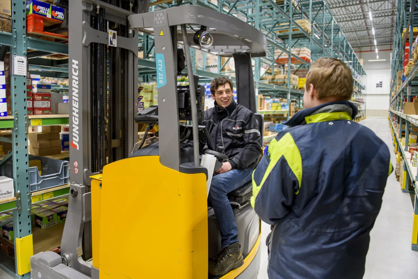 Studenten Transport & Logistiek werken samen in het magazijn op de heftruck