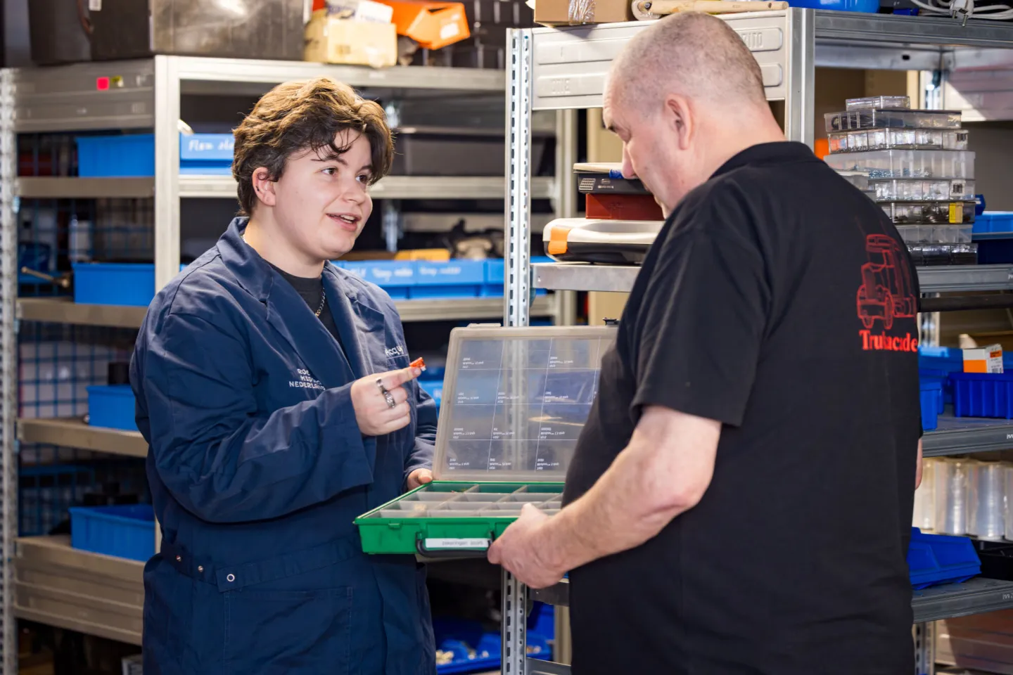 Student en docent van Bedrijfsautotechniek wisselen gereedschap uit