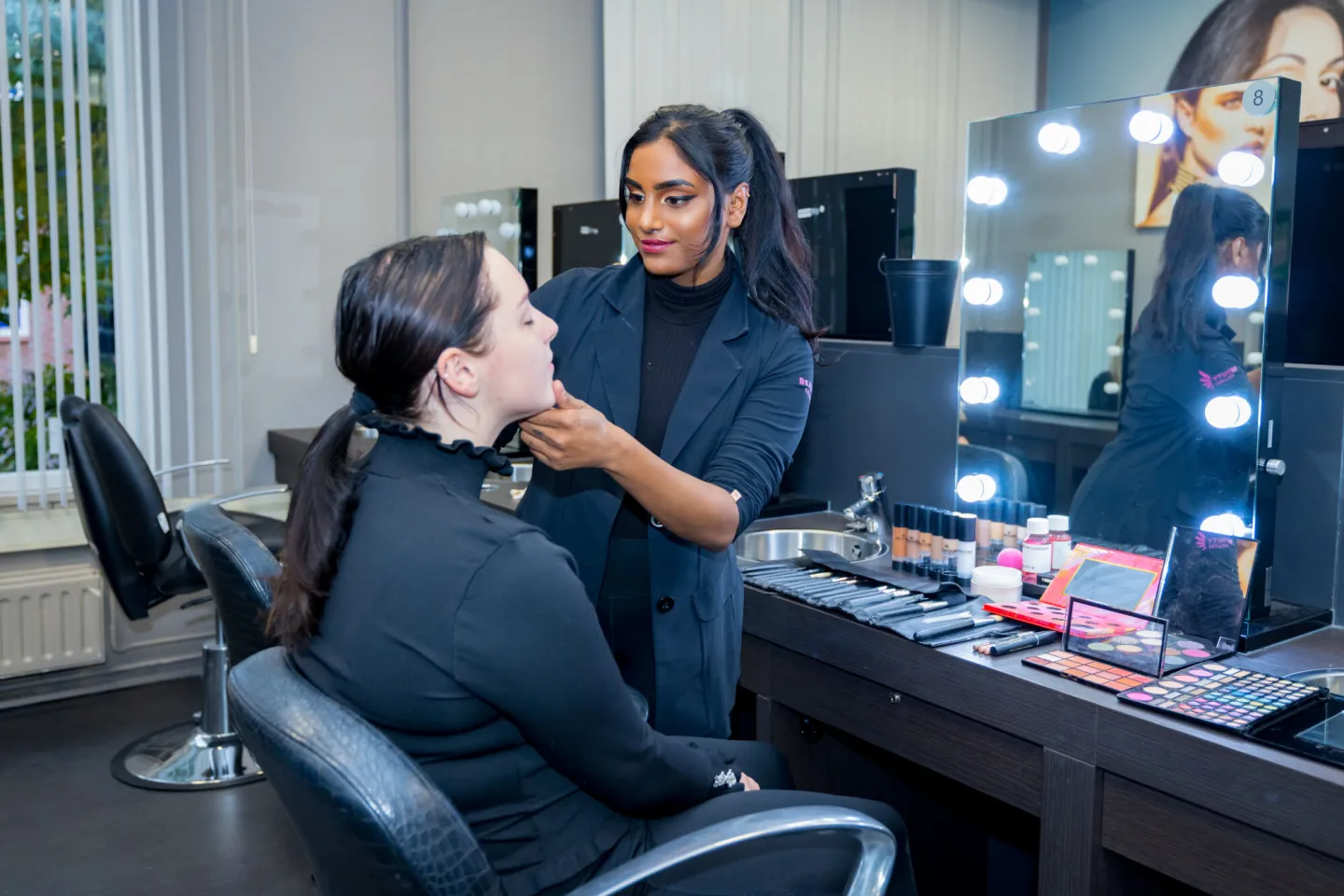 Een vrouw wordt opgemaakt door een make-up artiest.