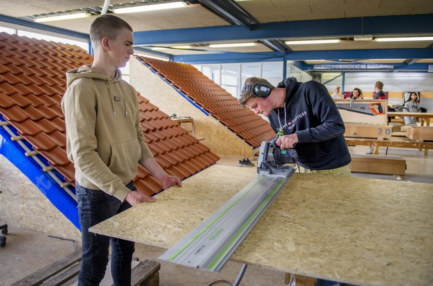 Studenten werken samen aan houtproject.