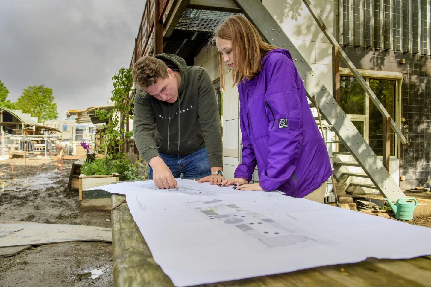 Studenten werken samen aan plannen van een bouwproject.