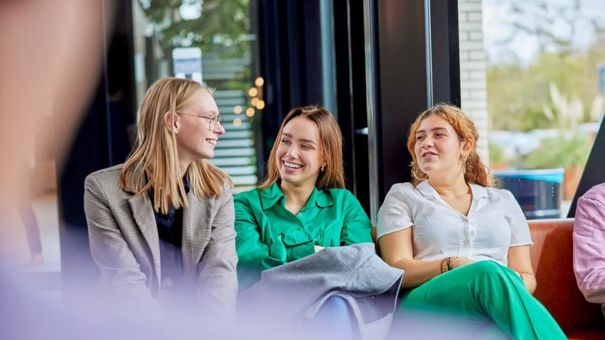 Drie studenten zitten op een rijtje op de bank