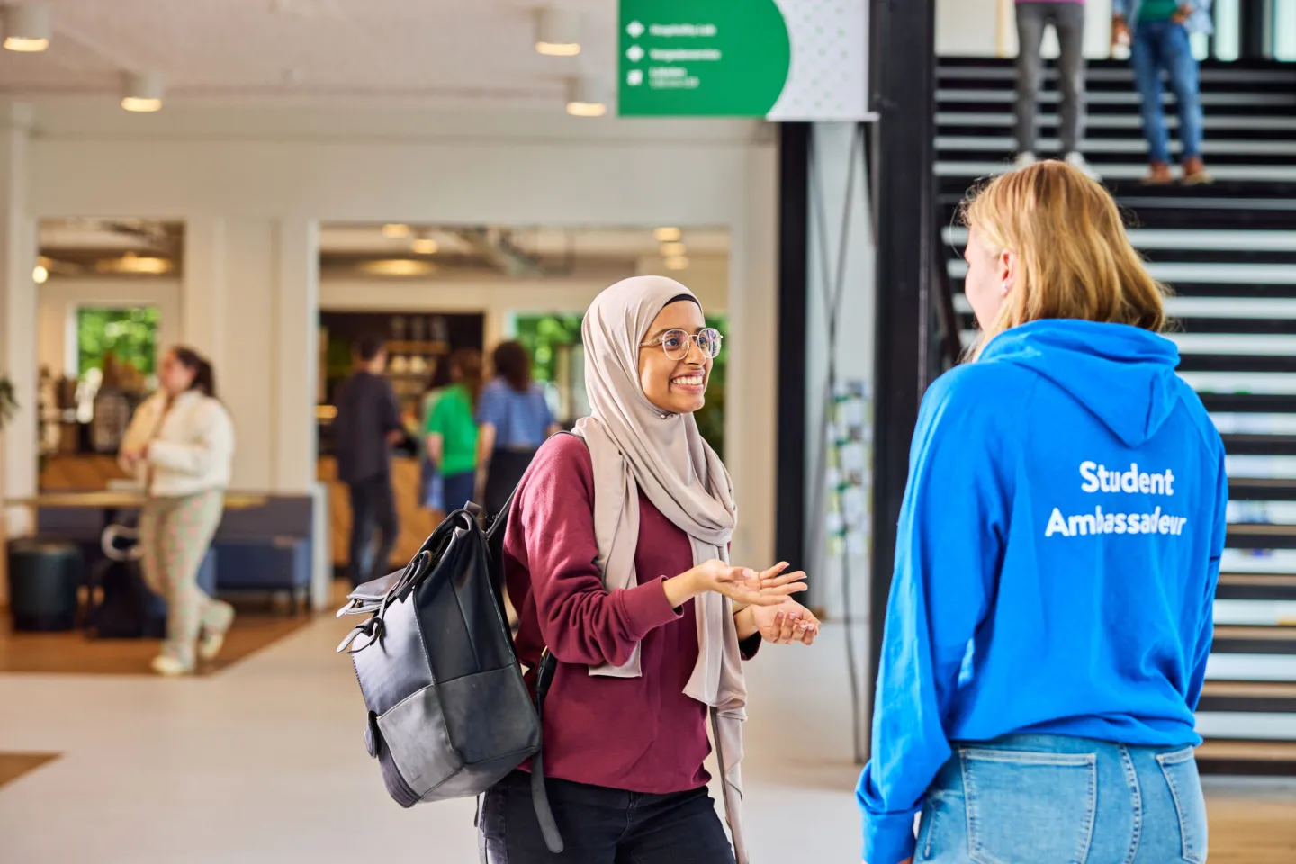 Een student en voorlichter die met elkaar in gesprek zijn in een school