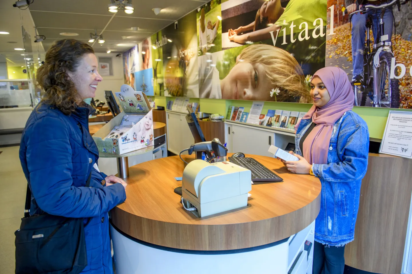 Klant vraagt medicijnadvies aan een medewerker in een apotheek.