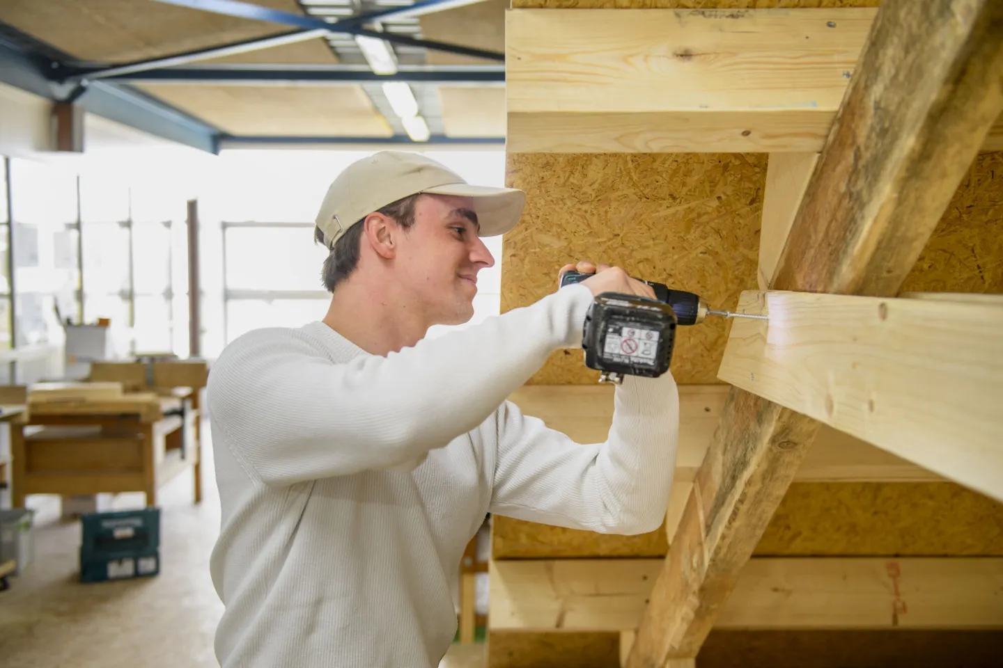 Student klust aan houten constructie 