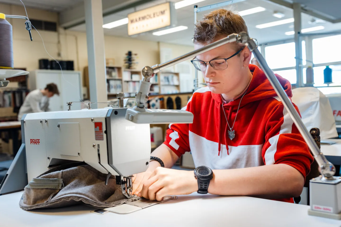 student meubelstofferen werkt achter naaimachine aan kussenhoes