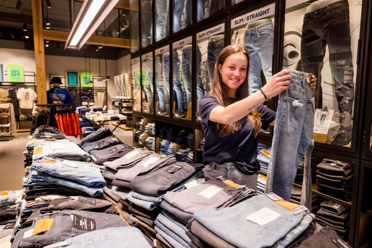 Student Retail vouwt jeans in winkel