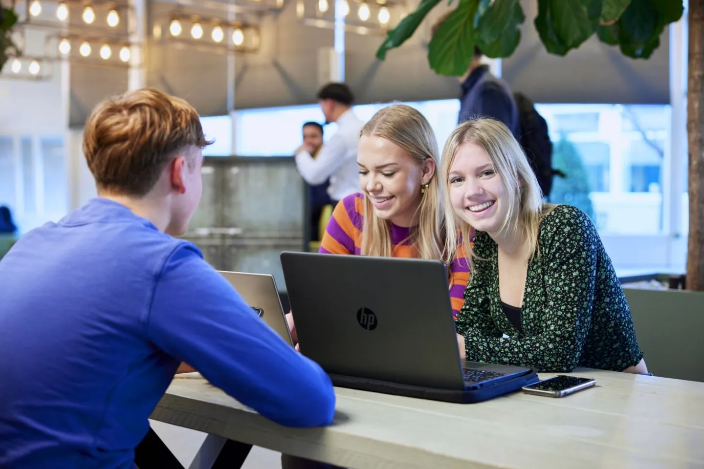 Studenten achter laptop in de kantine