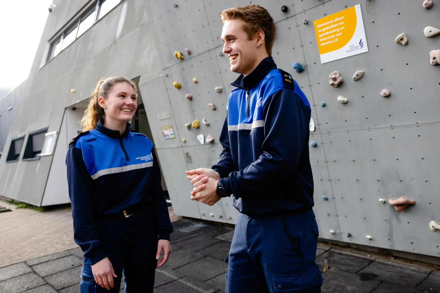 Studenten Handhaver Toezicht & Veiligheid (HTV) staan bij de klimmuur van Veiligheid & Defensie College