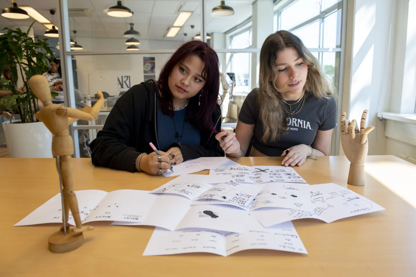 Studenten werken aan illustratie met dummypoppen