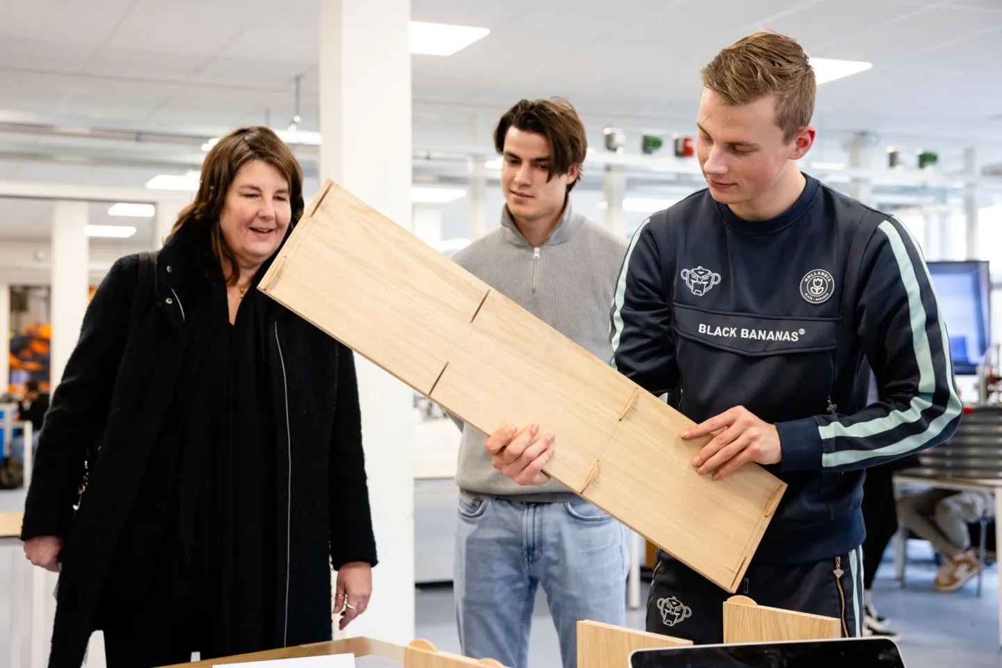 Studenten werken samen met hout aan een project 