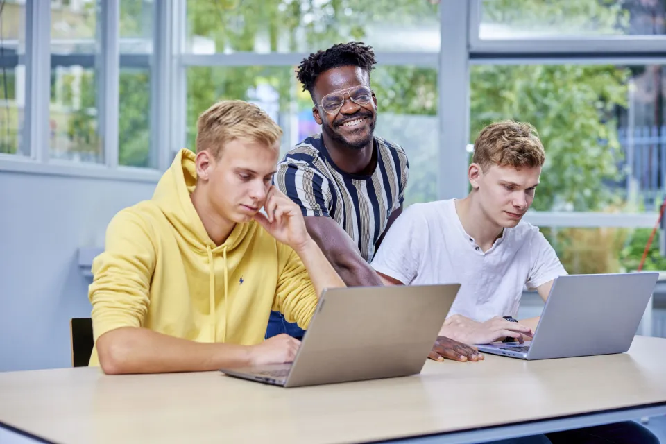 Drie studenten aan het werk achter de laptop