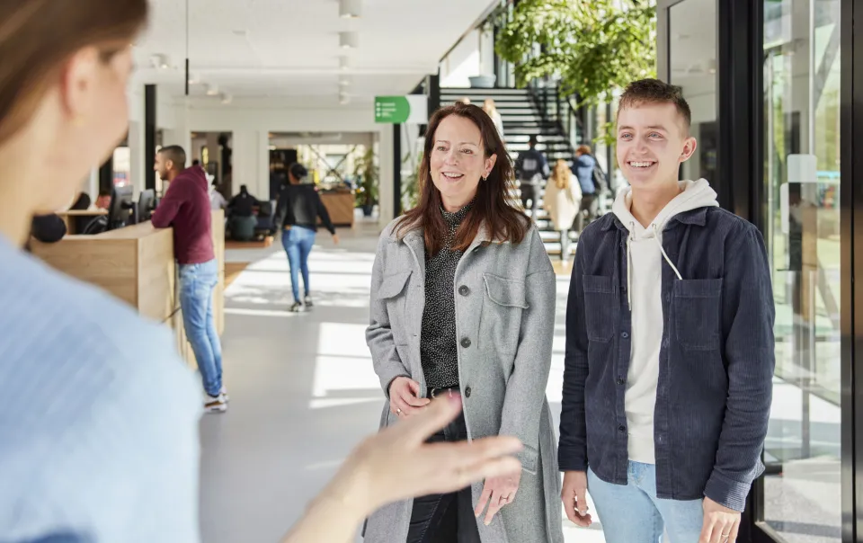 Een moeder en haar zoon worden welkom geheten op school