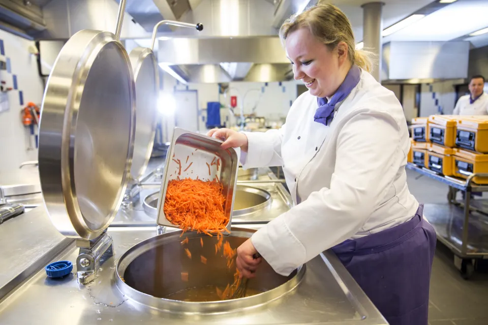 Een kok is aan het koken in de kombuis.