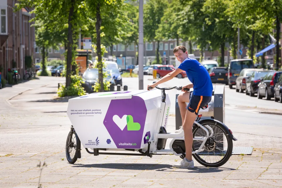 Student staat met mobiele vitaliteitslab in rivierenwijk Utrecht