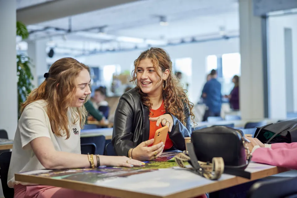 Twee studenten in kantine met elkaar in gesprek