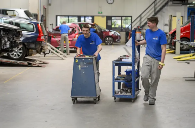 Studenten autospuiter zijn samen onderweg naar auto om te spuiten