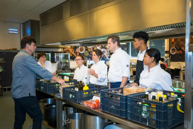 Cursisten controleren in de keuken ingrediënten op kwaliteit en houdbaarheid.