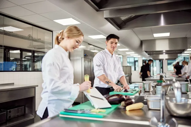 Studentleerling koks bereiden een menu in de keuken bij Horeca college