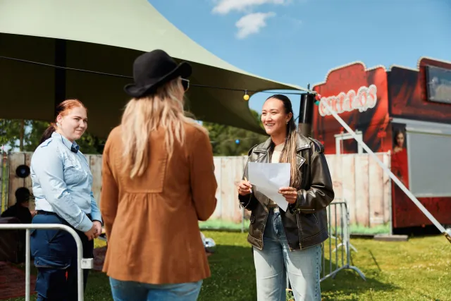 Student eventmanager begeleidt een artiest tijdens een festival