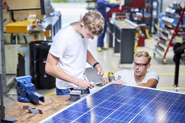 Twee studenten van Tech Campus zijn aan een zonnepaneel aan het werk