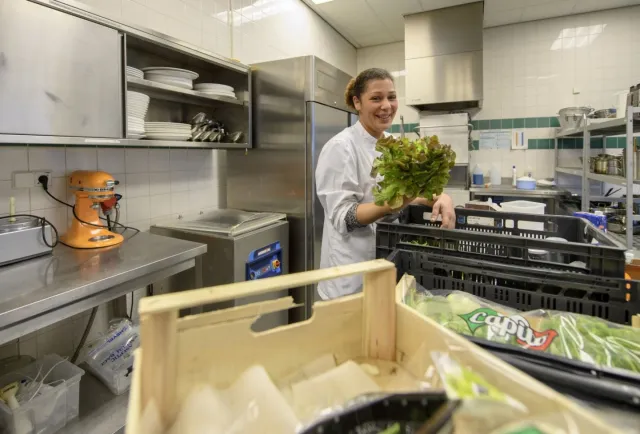 Kok is in de keuken werkzaamheden aan het voorbereiden.