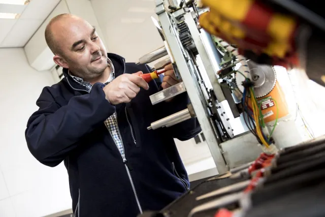 Student aan het werk bij een machine met een schroevendraaier 