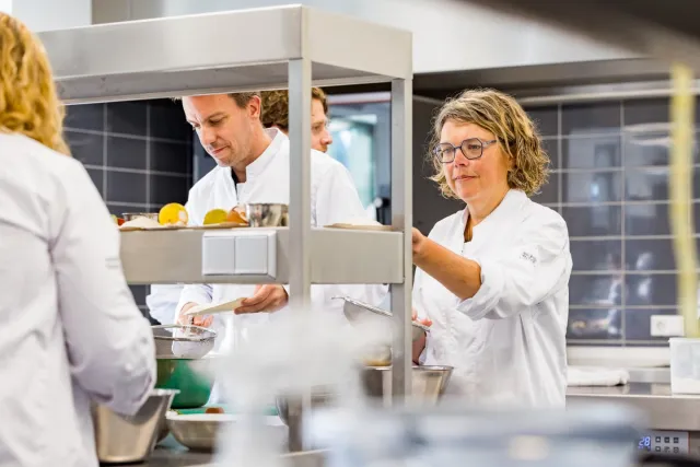 Deelnemers koksopleiding aan het werk in de keuken