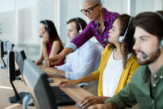 Leidinggevende geeft instructies aan medewerkers van callcenter.