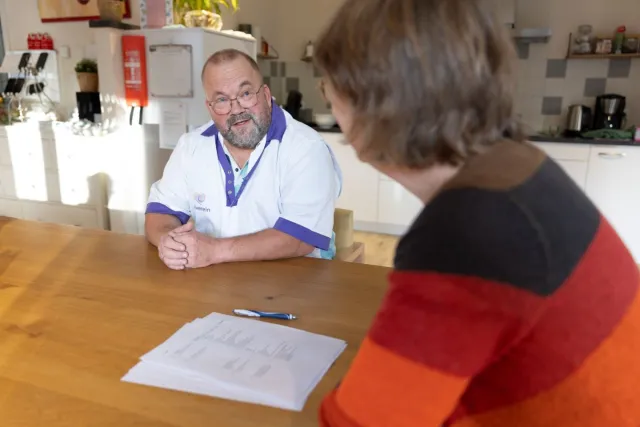 Praktijkopleider voert beoordelingsgesprek met student aan tafel. 