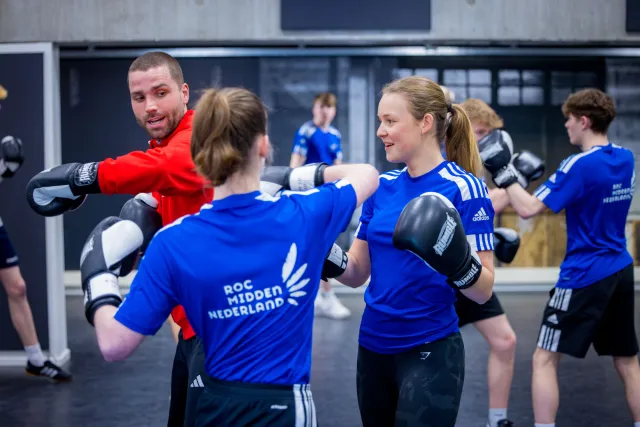 Twee meisjes in sportieve outfits trainen in een sportschool. Ze zijn klaar voor een intensieve bokssessie.