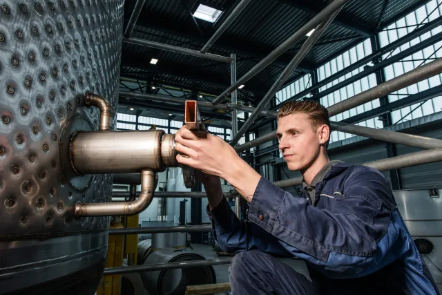 student Monteur Service en Onderhoud Installaties en Systemen werkt met gereedschap