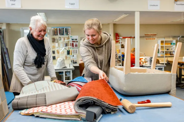 Student en docent kiezen samen een geschikte stof voor een meubel uit 