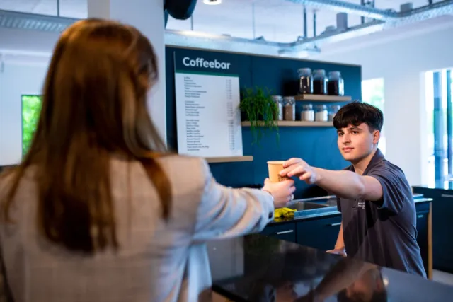 Student Facilitair Dienstverlener voor anderstaligen werkt achter de Coffeebar 