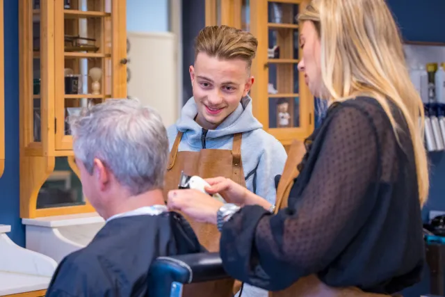 Student van de opleiding Salonmanager in gesprek met een klant in het praktijklokaal 