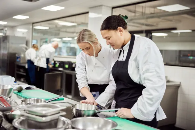 Studenten Kok werken samen in de keuken op school 