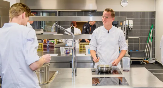 Twee studenten kok werken samen in de keuken om verschillende gerechten te bereiden