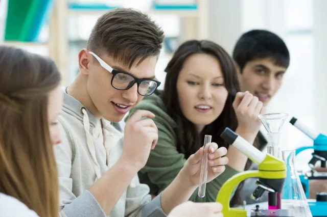 Vier leerlingen doen een opdracht in een practicumlokaal. 