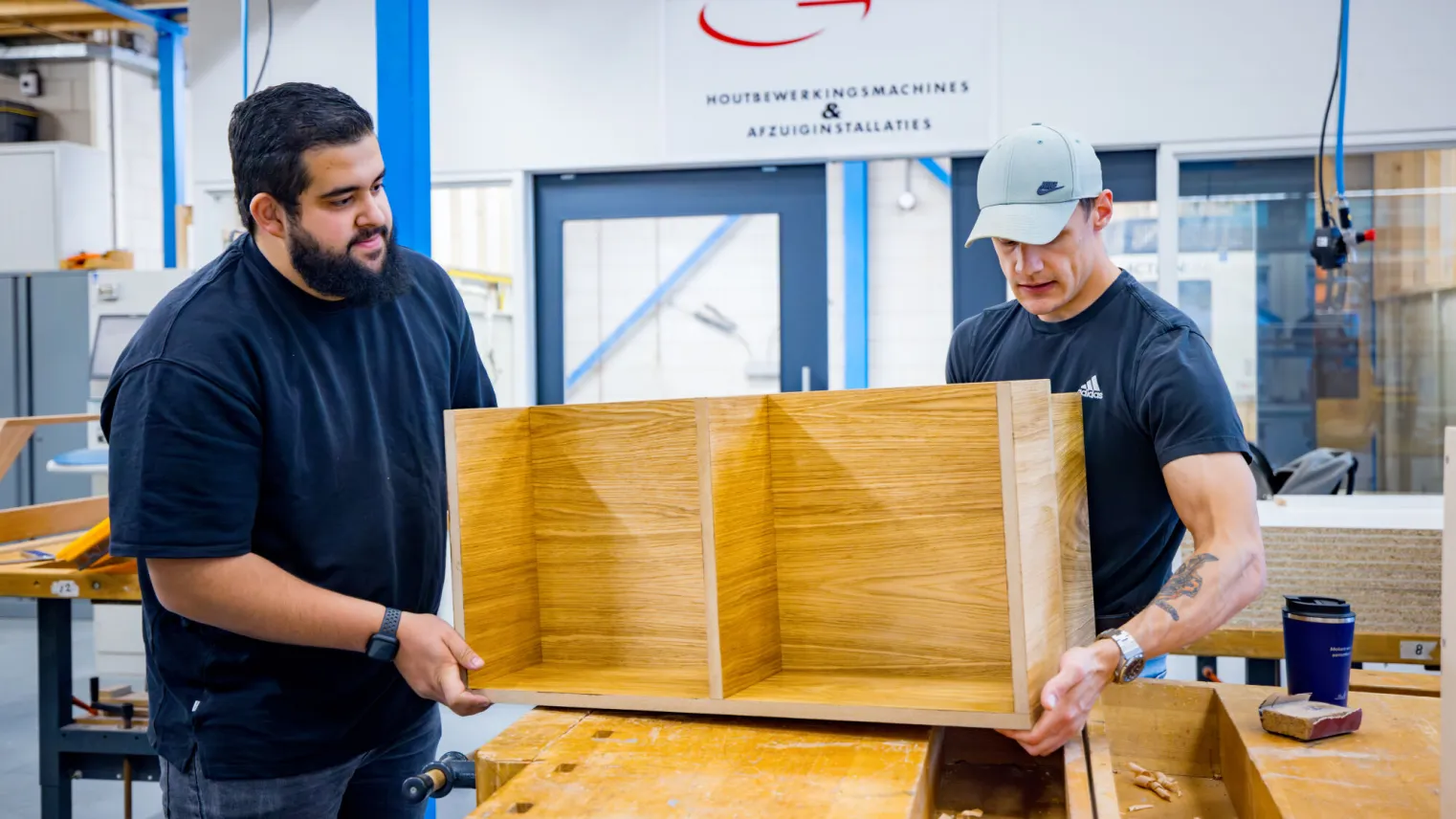 student werkt samen met docent aan meubel project