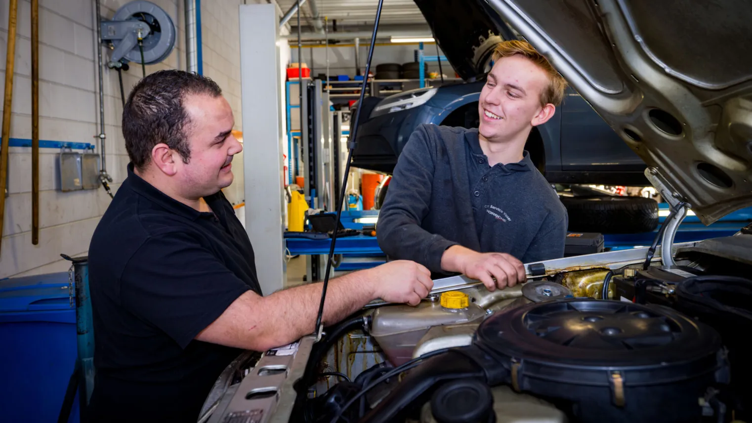 Student sleutelt aan auto met docent in garage