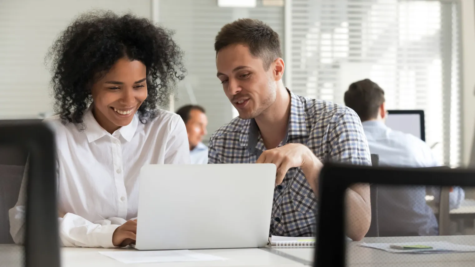 Twee cursisten zijn samen aan het werk achter de laptop 