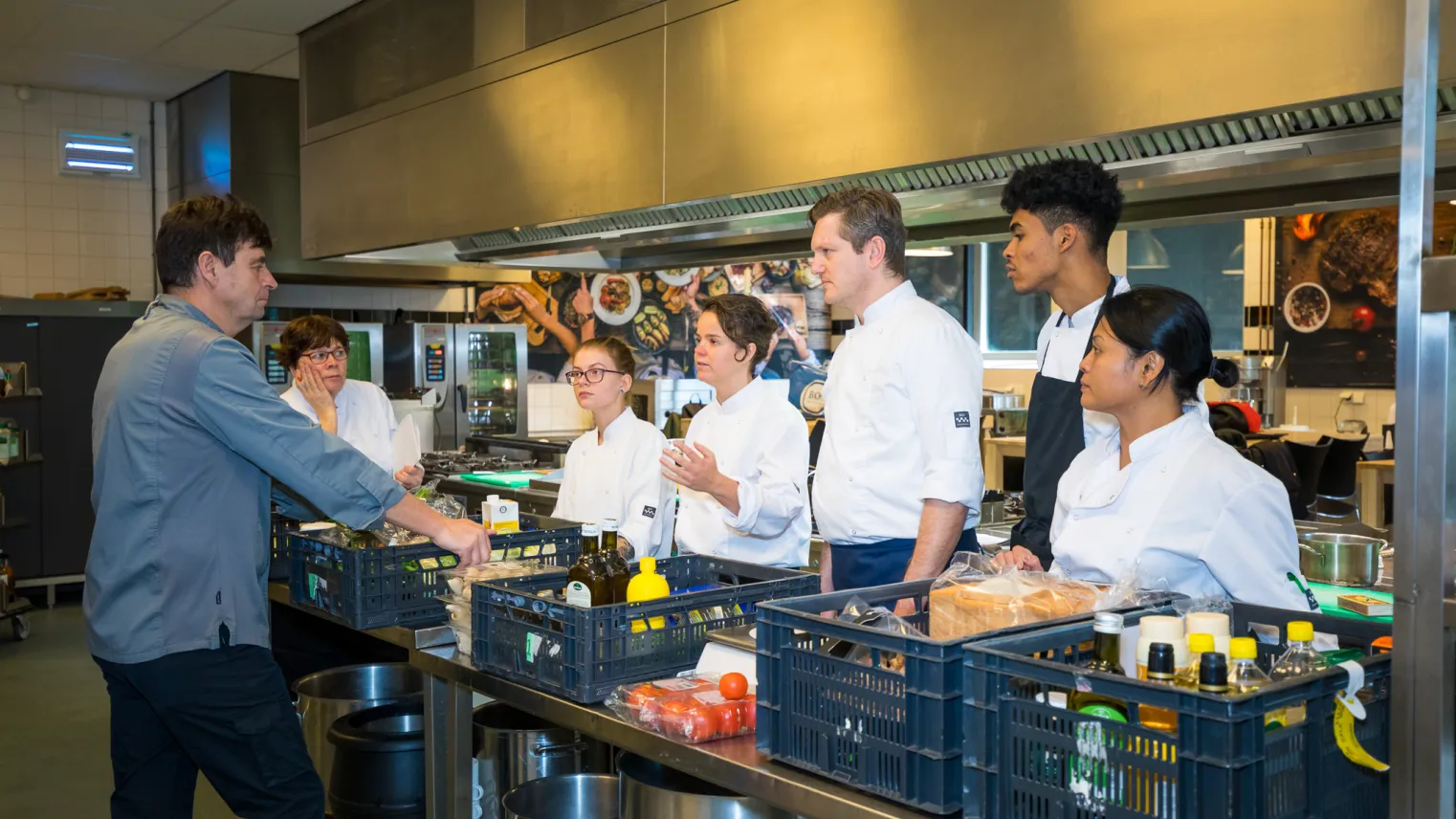 Cursisten controleren in de keuken ingrediënten op kwaliteit en houdbaarheid.