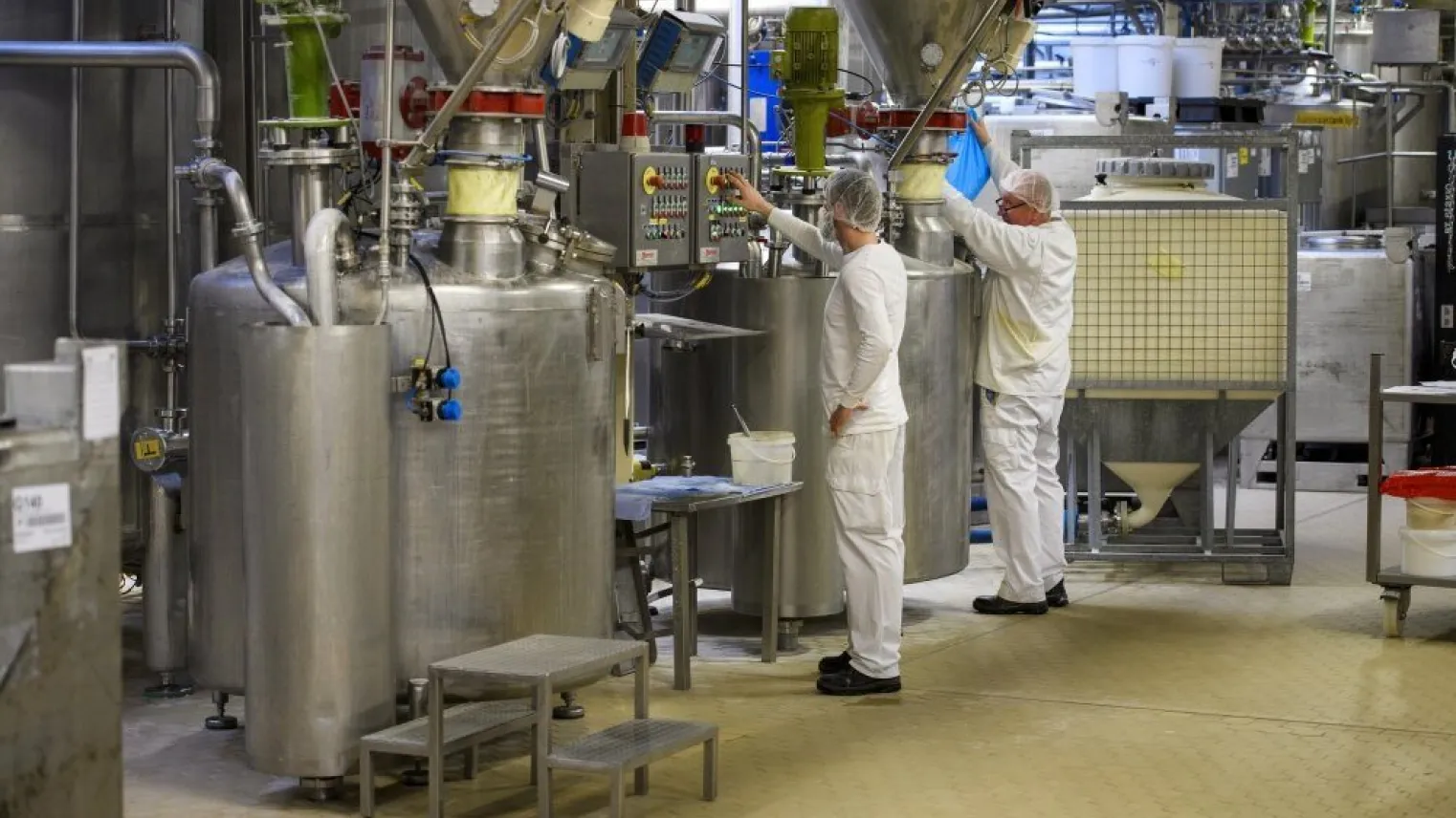 Een student in een fabriek met praktijkbegeleider die Lean en Creatief een proces inricht bij een controlepaneel. 