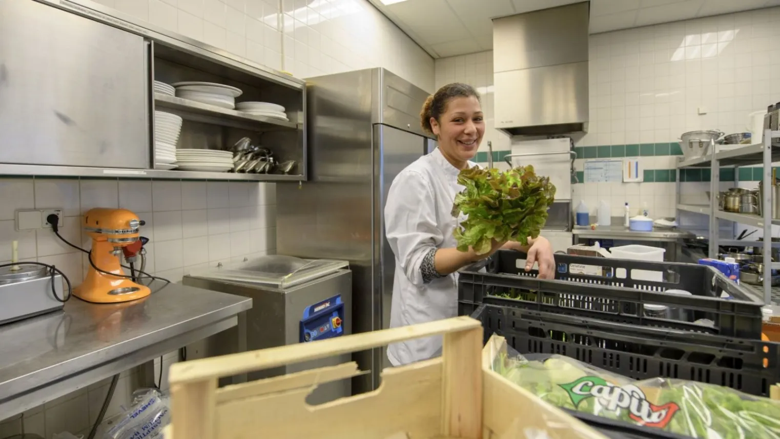 Kok is in de keuken werkzaamheden aan het voorbereiden.