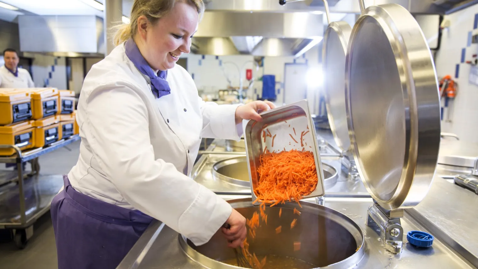 Een kok is aan het koken in de kombuis.