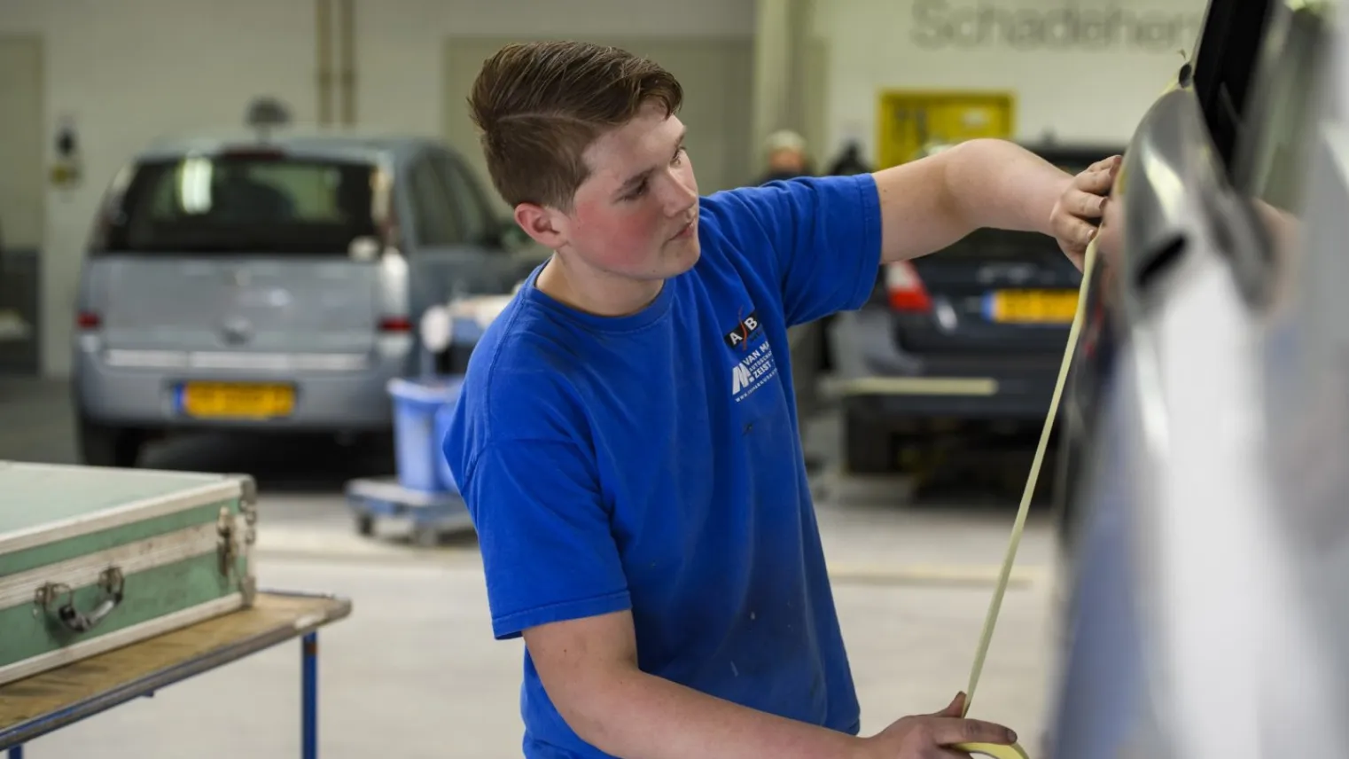 Student autospuiter is aan het werk in de garage