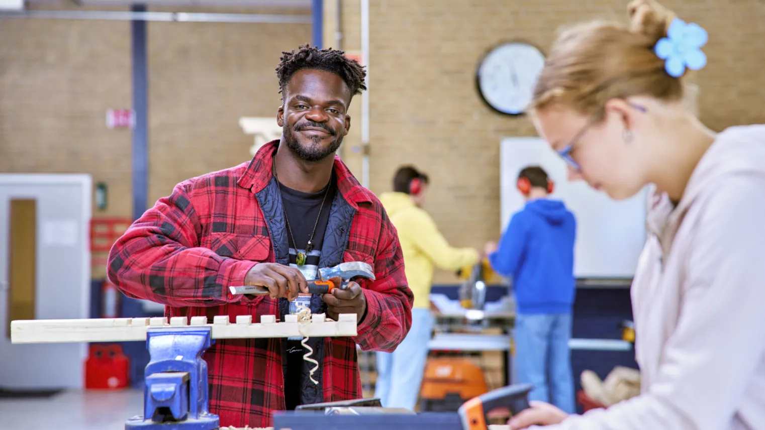 Student aan opleiding Werkvoorbereider werkt aan de bouw van een groot object van hout.