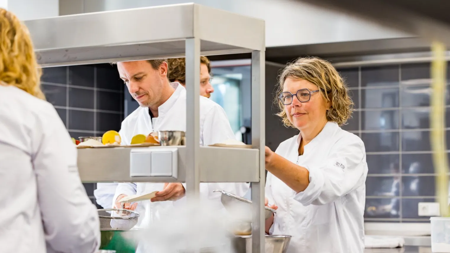 Deelnemers koksopleiding aan het werk in de keuken